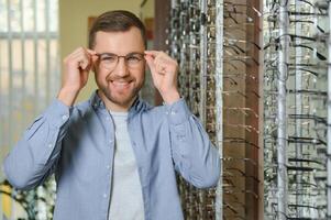 zufrieden Kunde. Über das Schulter Aussicht von glücklich jung männlich Klient tragen Neu Brille. foto