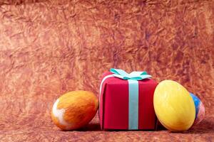 Ostern Hintergrund mit farbig Eier und rot Geschenk Box auf braun Hintergrund mit Kopieren Raum. glücklich Ostern. foto