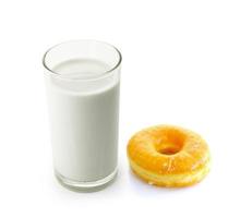 Glas Milch und Donut auf weißem Hintergrund foto