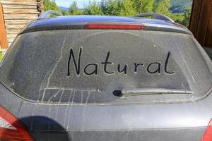 Worte Natur auf der staubigen, schmutzigen Windschutzscheibe eines Autos foto