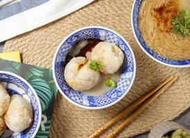 klein Fleischklößchen mit Essstäbchen und Löffel serviert im Schüssel isoliert auf Tabelle oben Aussicht von Chinesisch Essen foto