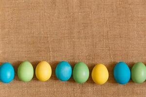 Farbe Eier zum Ostern, hell Ostern Urlaub, Kinder Farbe Eier, farbig Eier im ein Korb, farbig Eier auf ein Stand, Urlaub Hintergrund foto