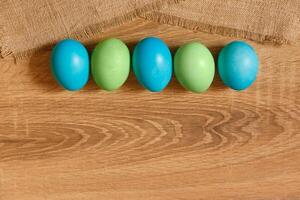 Farbe Eier zum Ostern, hell Ostern Urlaub, Kinder Farbe Eier, farbig Eier im ein Korb, farbig Eier auf ein Stand, Urlaub Hintergrund foto