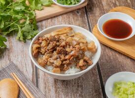 Schweinefleisch Reis mit Chili Soße, Nudeln, Löffel und Essstäbchen serviert im Gericht isoliert auf Serviette oben Aussicht von Hong kong Essen foto