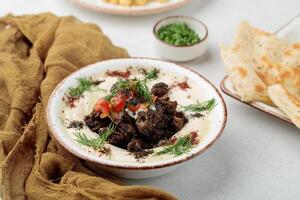 Hummus mit Tikka serviert im Gericht isoliert auf Tabelle oben Aussicht von arabisch Essen foto