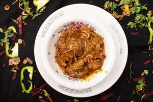 Rindfleisch bhuna Karahi serviert im Gericht isoliert auf dunkel Hintergrund oben Aussicht von indisch Gewürze Essen foto