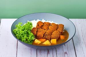 traditionell japanisch Essen Reis Löwe Mähne käsig Pastetchen Curry im ein Schüssel auf hölzern Tabelle foto