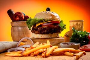 Grill Rindfleisch Käse Burger mit Französisch Fritten, Kartoffel und Tomate Scheibe isoliert auf hölzern Tafel Seite Aussicht auf Tabelle schnell Essen foto