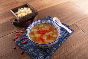 aufgetaut würzig gefroren Süss Suppe rot Termine, Schnee Pilz und Lotus Saat serviert Gericht isoliert auf hölzern Tabelle oben Aussicht von Hong kong Essen foto