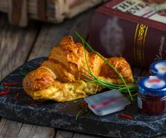 Croissant Omelett serviert im ein Gericht isoliert auf Schneiden Tafel Seite Aussicht von Frühstück auf hölzern Hintergrund foto