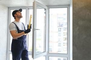 das Vorarbeiter installiert ein Fenster Rahmen im das Zimmer foto