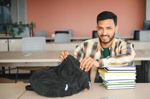 gut aussehend jung indisch Junge Schüler mit Bücher und Rucksack beim Universität. Bildung Konzept foto