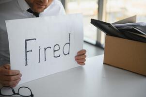 gefeuert Mitarbeiter halten gefeuert Zeichen im Hand foto