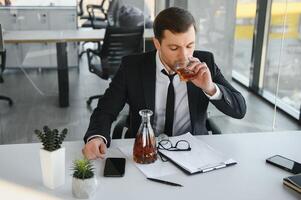 Geschäftsmann Trinken von Stress beim Arbeitsplatz foto