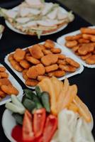 Hochzeitsbuffet mit Nuggets, Canape, Sandwiches und Gemüse foto