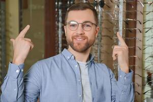 groß Auswahl. stilvoll Mann mit Bart wählen Brille im das Optik speichern. foto