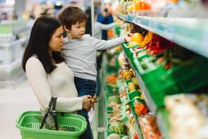 Frau und Kind Junge während Familie Einkaufen mit Wagen beim Supermarkt foto