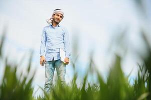 Sorge weniger ,indisch Farmer Stehen im seine gesund Weizen Feld foto