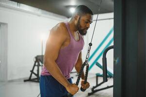 Gewicht Ausbildung afrikanisch tun Bodybuilding im Fitnessstudio. foto