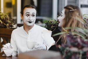 Pantomimen im Vorderseite von Paris Cafe Schauspielkunst mögen Trinken Tee oder Kaffee. foto