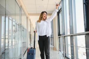 glücklich Frau Reisen und Gehen im Flughafen foto