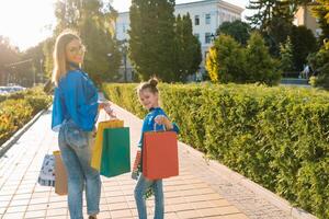 Verkauf, Konsumismus und Menschen Konzept - - glücklich jung Frauen ihr dauther mit Einkaufen Taschen Gehen Stadt Straße foto