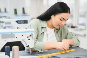 jung Frau Arbeiten wie Näherin im Kleidung Fabrik. foto