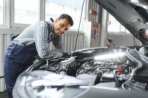 indisch glücklich Auto Mechaniker im Blau Anzug. foto