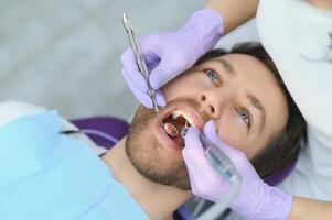 Mann mit Zähnen bei Zahnärzten untersucht foto