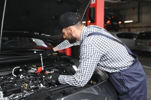 Erwachsene Mann im Blau farbig Uniform funktioniert im das Automobil Salon. foto