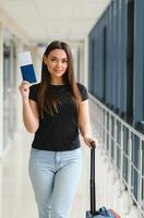 ziemlich Frau warten zum ihr Flug beim Flughafen foto