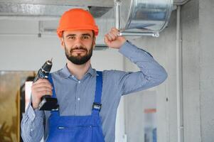 hvac Arbeiter Installieren geleitet Rohr System zum Belüftung und Luft Konditionierung. Kopieren Raum foto