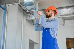 hvac Ingenieur Installieren Hitze Wiederherstellung Belüftung System zum Neu Haus. Kopieren Raum foto