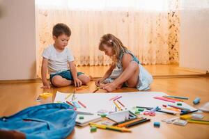 Kinder Zeichnung auf Fußboden auf Papier. Vorschule Junge und Mädchen abspielen auf Fußboden mit lehrreich Spielzeuge - - Blöcke, Zug, Eisenbahn, Ebene. Spielzeuge zum Vorschule und Kindergarten. Kinder beim Zuhause oder Kindertagesstätte foto