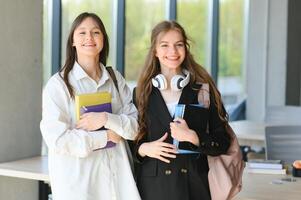 lächelnd Mädchen im hoch Schule Gang. zwei weiblich Hochschule Studenten reden nach Vorlesung. foto