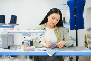 positiv jung Frau Nähen mit Fachmann Maschine beim Werkstatt. foto