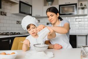 glücklich Familie. Mutter Lehren ihr Sohn Wie zu Kochen Kuchen Speisekarte im Morgen. gesund Lebensstil Konzept.. Backen Weihnachten Kuchen und Koch Konzept foto