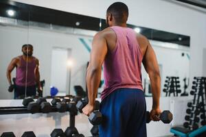 Porträt afrikanisch amerikanisch Bodybuilder beim Fitnessstudio heftig einschüchternd Blendung Ausdruck Überzeugung. foto