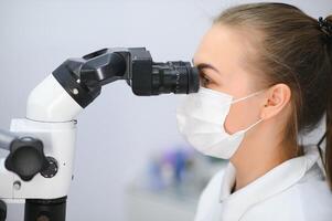 weiblich Zahnarzt mit Dental Mikroskop Behandlung geduldig Zähne beim Dental Klinik Büro foto