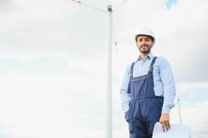 Indien Ingenieur beim Windmühle Bauernhof Betrieb zu generieren Elektrizität, asiatisch Mann Arbeiten beim Wind Turbine Bauernhof, sauber und Grün Energie. foto