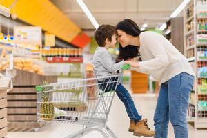 Mutter mit Sohn beim ein Lebensmittelgeschäft Geschäft foto