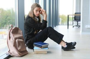 verärgert Teen Mädchen sitzen auf Fußboden traurig aussehen aus Fenster besorgt Über Teenager Problem beim Schule und Kommunikation mit Elternteil. besorgt Mädchen gespannt leiden Über Tyrannisieren beim Schule foto