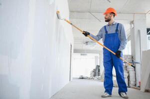 Maler Mann Gemälde das Wand, mit Farbe Walze foto