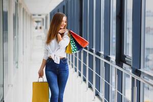 Mode Einkaufen Mädchen Porträt. Schönheit Frau mit Einkaufen Taschen im Einkaufen Einkaufszentrum. Käufer. Verkauf. Einkaufen Center foto