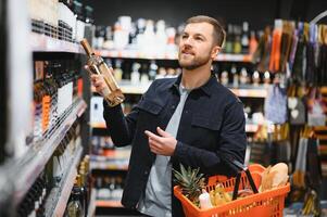 Mann im ein Supermarkt wählen ein Wein foto