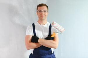 junge arbeiterin, die wand im zimmer malt foto