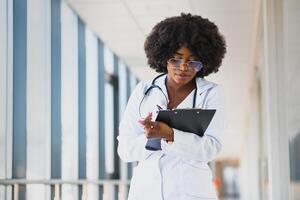 schön afrikanisch amerikanisch weiblich pädiatrisch Krankenschwester im modern Büro foto