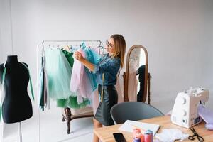 Arbeiten auf Neu Sammlung. Neu Befehl. weiblich Mode Designer funktioniert auf das Neu Kleider im das Werkstatt. foto
