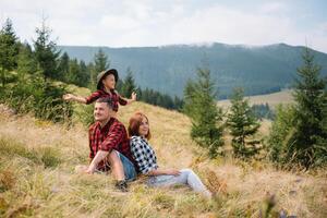 Vater und Kind Wandern im szenisch Berge. Papa und Sohn genießen das Aussicht von das Berg oben im Karpaten Berge. foto