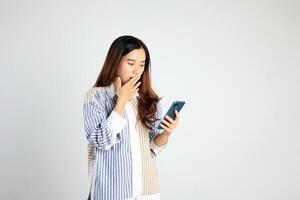 jung asiatisch weiblich mit Smartphone Stehen mit Abdeckung Mund foto